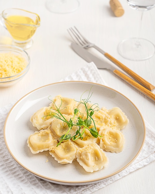 Foto pasta de ravioli italiana tradicional de forma quadrada recheada com queijo em prato com um copo de vinho