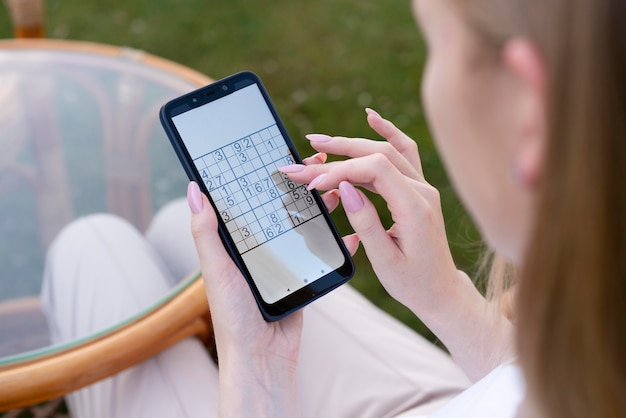 Person, die ein Sudoku-Spiel auf einem Smartphone spielt