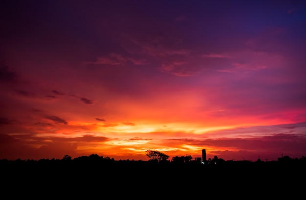 Por do sol bonito com fundo do céu azul e das nuvens.