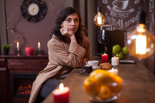 Porträt einer schönen jungen Frau, die in die Kamera schaut und an der Bartheke in einem Elengat-Café sitzt. Wunderschöne kaukasische junge Frau in einem Café.