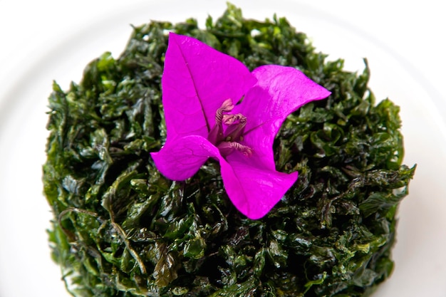 Prato de salsa frita guarnecido com flor de buganvílias na mesa de madeira comida contemporânea