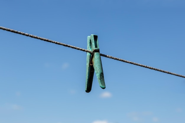 Prendedor de roupa pendurado em um varal com céu azul