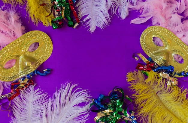 Foto quadro de carnaval colorido com máscaras e penas e fundo roxo