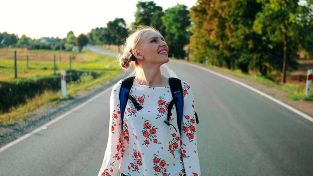 Reisende Frau, die ihren Rucksack aufhebt Backpacker-Frau hebt morgens ihre Tasche von der Straße ...