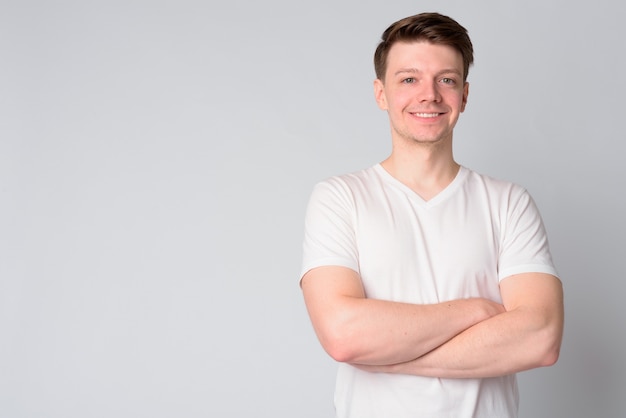 Foto retrato de jovem bonito feliz sorrindo com os braços cruzados