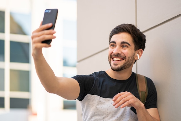 Retrato de jovem fazendo uma videochamada no celular enquanto está ao ar livre