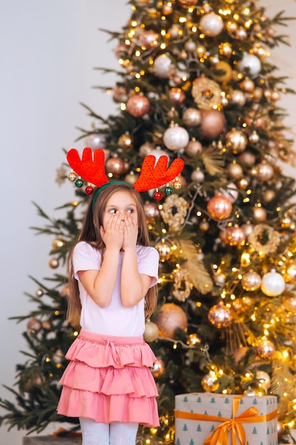 Retrato de menina usando chapéu de natal de veado Feriados de inverno e conceito de pessoas