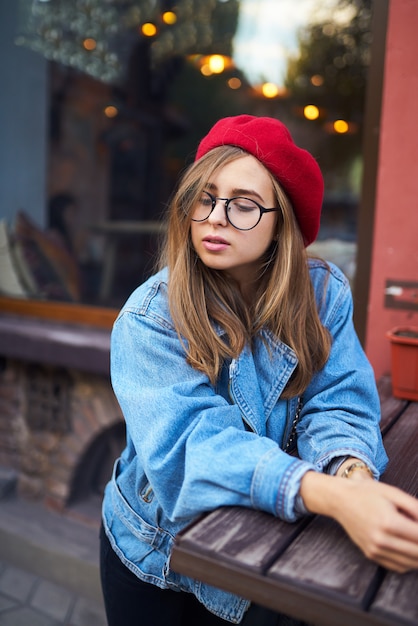 Retrato de moda verão ensolarado estilo de vida da mulher jovem hippie elegante andando na rua, vestindo roupa bonita da moda com chapéu vermelho