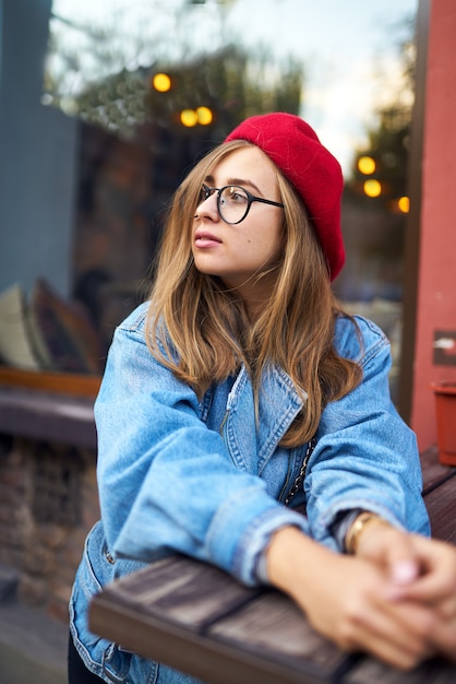 Retrato de moda verão ensolarado estilo de vida da mulher jovem hippie elegante andando na rua, vestindo roupa bonita da moda com chapéu vermelho