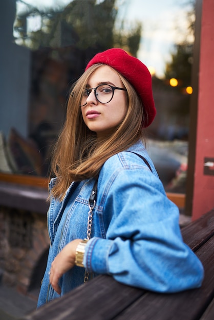 Retrato de moda verão ensolarado estilo de vida da mulher jovem hippie elegante andando na rua, vestindo roupa bonita da moda com chapéu vermelho