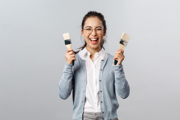 Foto retrato de uma jovem sorridente contra um fundo cinzento