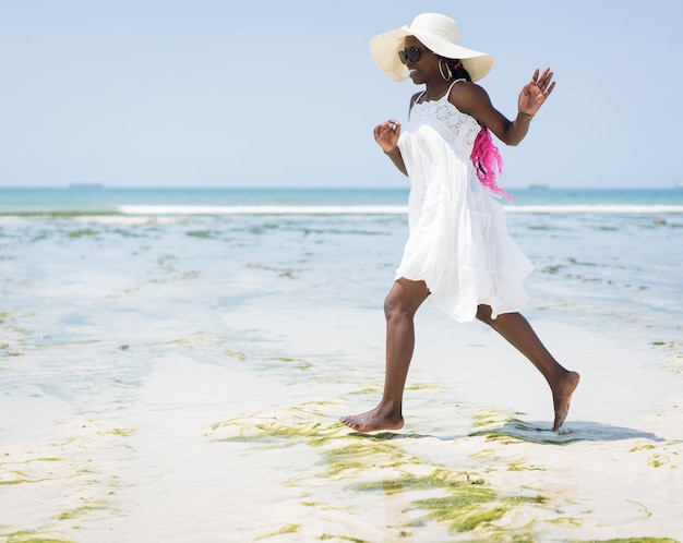 Schöne junge schwarze Afroamerikanerin am tropischen Strand