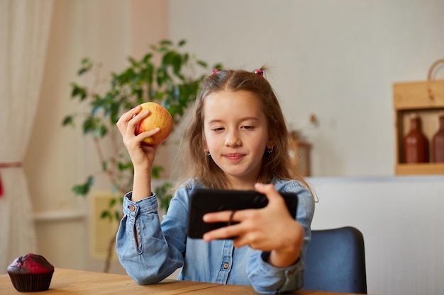 Schönes junges Mädchen, das ihre Blog-Sendung über gesunde Ernährung zu Hause filmt