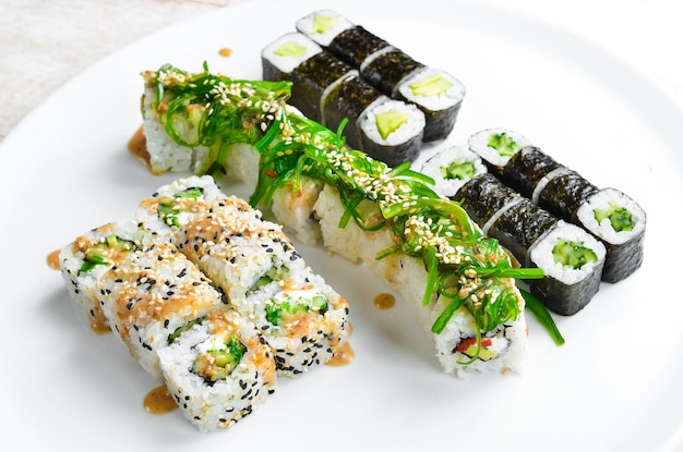 Foto set sushi-rollen mit aal, sesam, avocado und fisch japanisches essen draufsicht auf weißem hintergrund