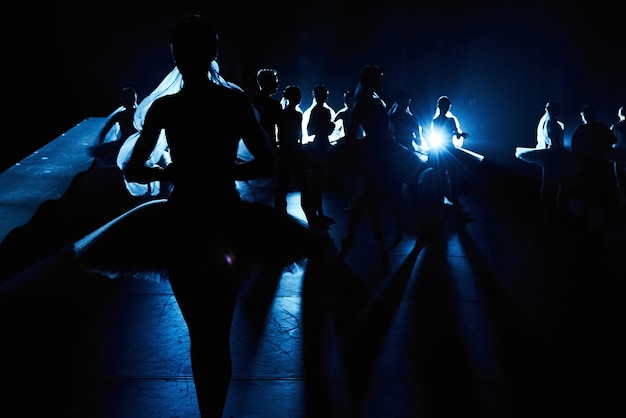 Silhuetas de bailarinas lotadas nos bastidores em uma bela luz