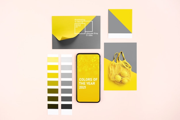 Foto smartphone mit ultimate grey und illuminating colours of the year 2021 und modischen farbfeldern. collage mit farbtrendpalette.