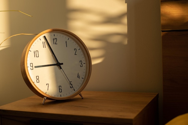 Sonnenschein auf Holzuhr im Schlafzimmer am Morgen