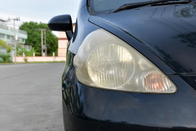 Superfície do farol danificada e borrada como resultado das condições climáticas e envelhecimento de um carro