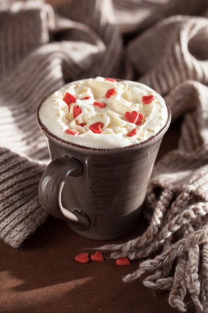 Tasse Kaffee mit Schlagsahne und roten Herzen