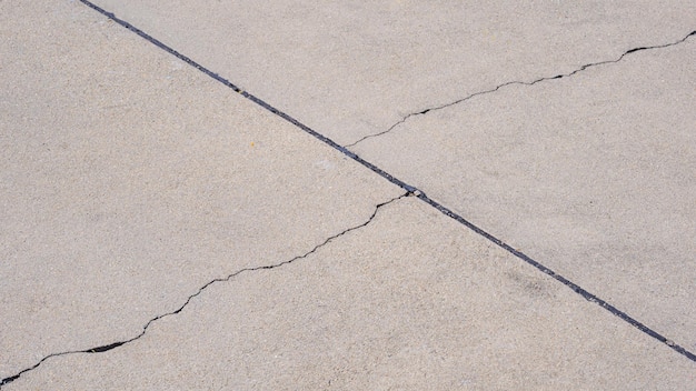 Foto textura de duas linhas de rachaduras na superfície do fundo do pavimento de concreto