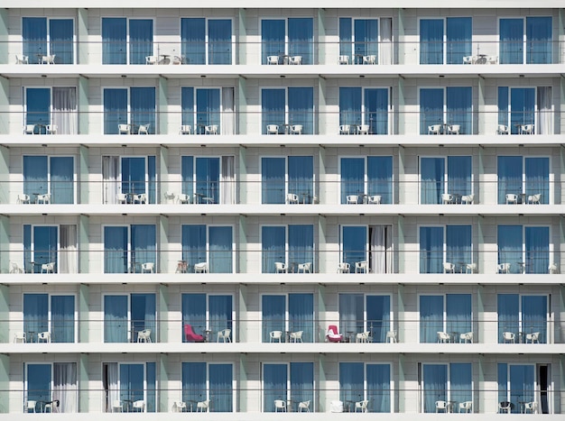 Textura do edifício residencial moderno ou fachada do hotel com varandas e cadeiras