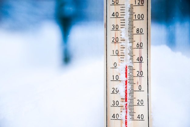 Thermometer auf Schnee mit niedrigen Temperaturen in Celsius oder Fahrenheit im Winter.