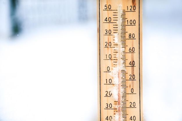 Thermometer auf Schnee mit niedrigen Temperaturen in Celsius oder Fahrenheit im Winter.