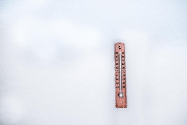 Thermometer auf Schnee mit niedrigen Temperaturen in Celsius oder Fahrenheit im Winter.