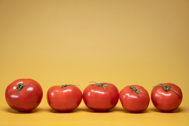 Tomates frescos em um fundo amarelo brilhante em um estilo de foto de comida de publicidade. Moldura horizontal