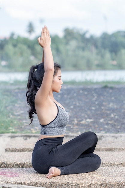 übendes Yoga der jungen Frau im Park