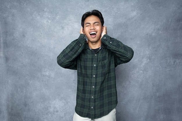 Foto um homem com as mãos na cabeça e as orelhas a cobrir os ouvidos é feliz.