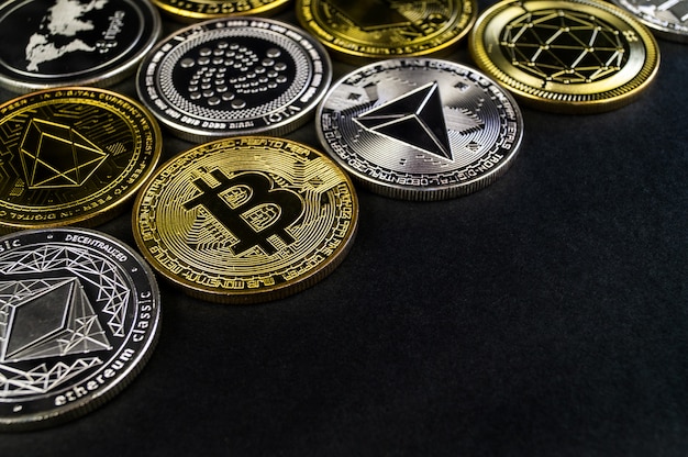 Foto um monte de moedas cryptocurrency mentir sobre uma superfície escura