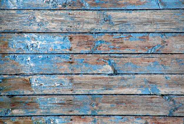 Velha pintura descascada azul em uma textura de madeira.