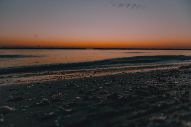 Foto vista de uma praia com um nascer do sol no fundo