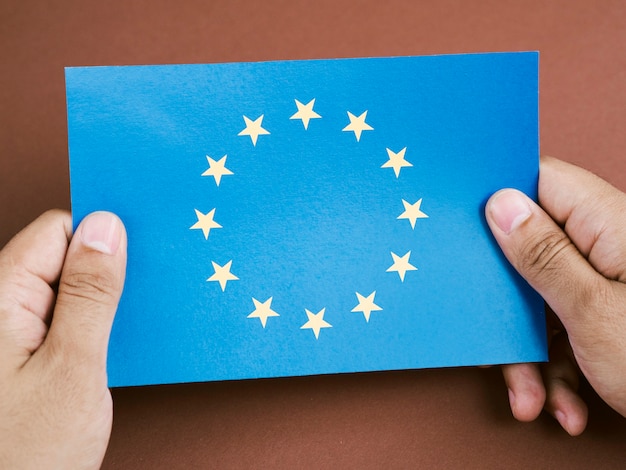 Vista frontal homem segurando um cartão com a bandeira da União Europeia