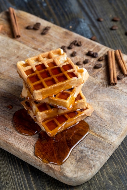 Waffles macios com mel de abelha natural em uma tábua de servir