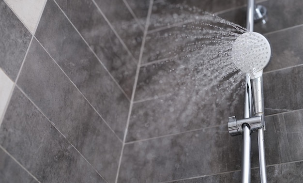 Wasser strömt aus dem Duschkopf in die Dusche