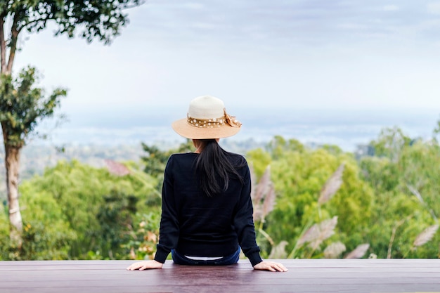 Weibliche Touristen, die auf dem hölzernen Balkon allein auf dem Berg sitzen