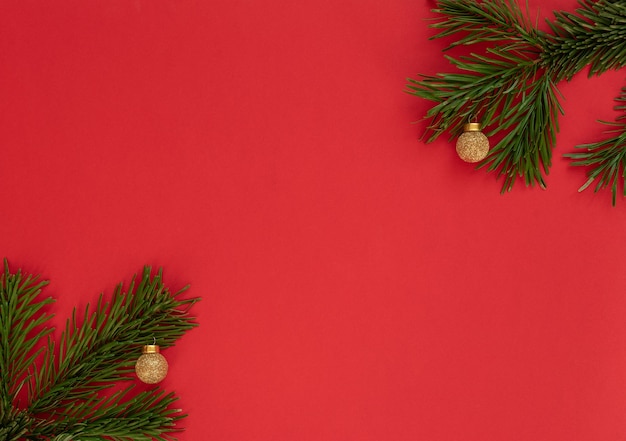 Weihnachtshintergrund mit Tannenzweigen und Goldkugeln.