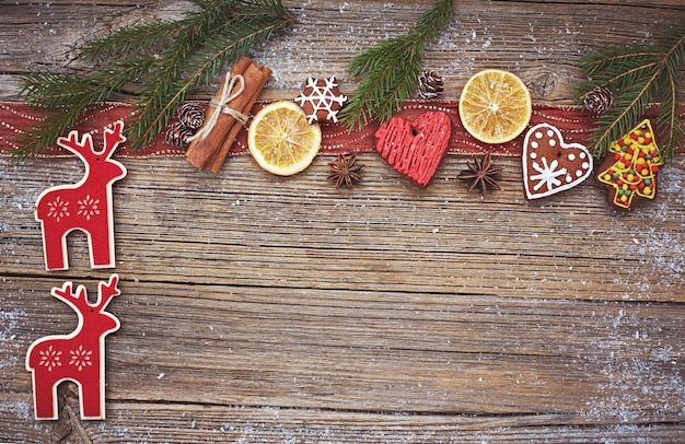 Weihnachtshölzerner Hintergrund mit hausgemachtem Weihnachtsplätzchen-Hirsch-Zimt und Weihnachtsbaum getönt