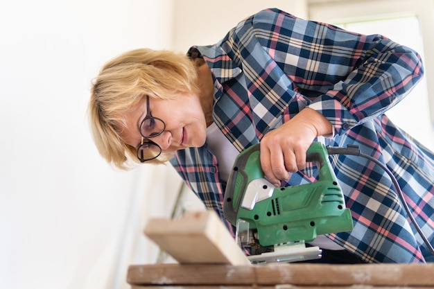 Woman Builder im Zimmer des Hauses, das Reparaturen durchführt