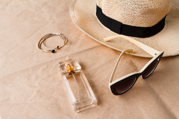 Free photo accessories sunglasses perfume and hat over craft surface