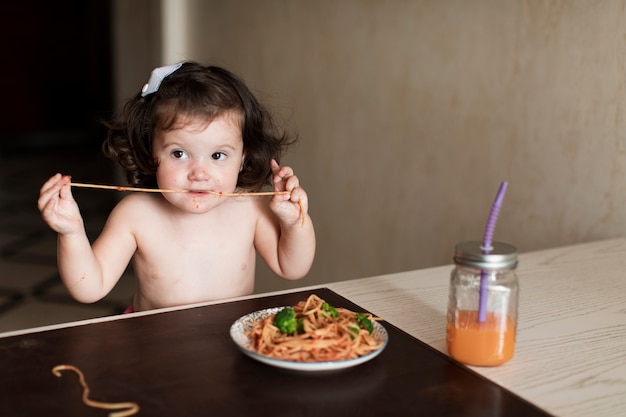 Foto gratuita ragazza adorabile che mangia spaghetti