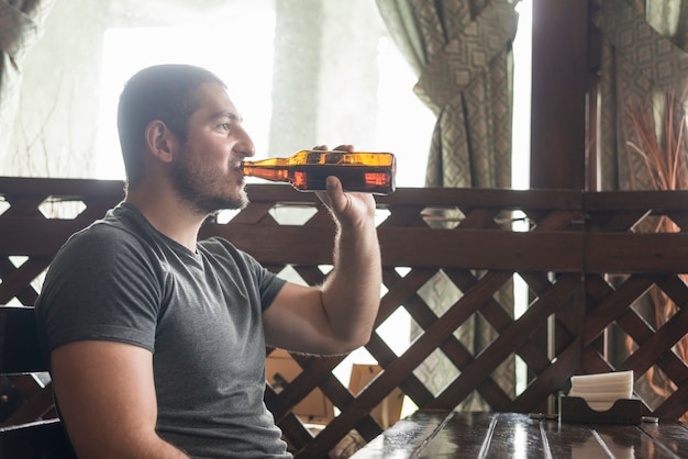 Free photo adult man drinking fresh beer in bar