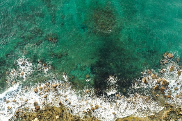 Free photo aerial view of sea meeting rocky shore