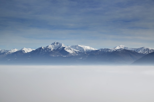 Free Photo amazing aerial view of mountains partially covered with snow and positioned higher than clouds