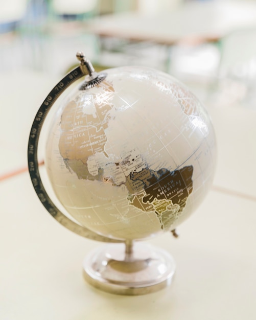 Free photo artistic white and silver globe on desk