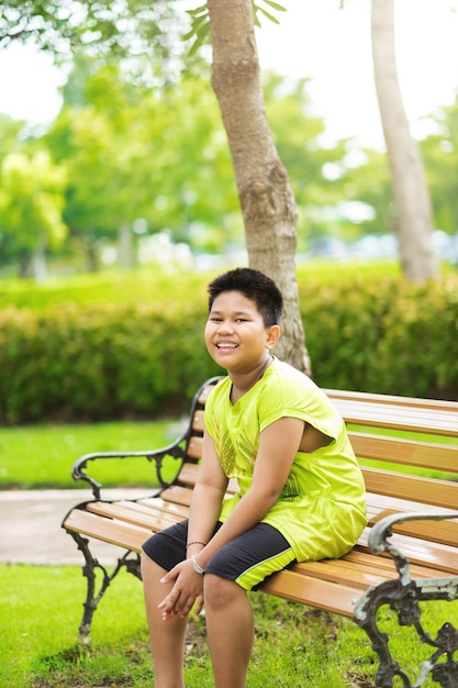 Free photo asain cute little boy sitting with green nature