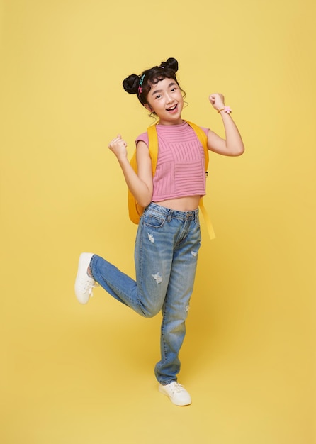 Free Photo asian child student gesture happy celebrating isolated on yellow background winner concept