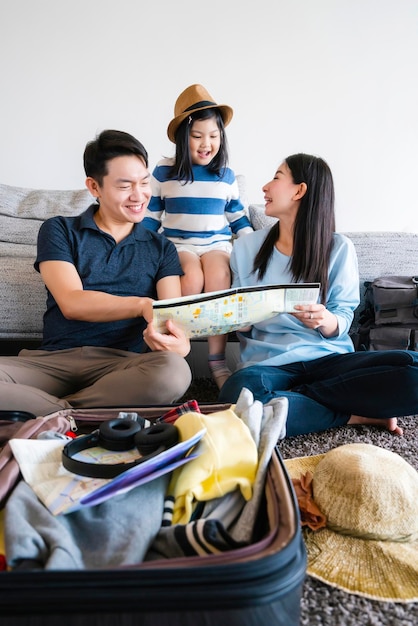 Free photo asian family travel concept happiness dad mom daughter packing stuff and planing for vacation trip with exited and joyful